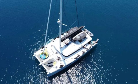 Atlantis yacht seen from above in open sea, mast and deck seating visible