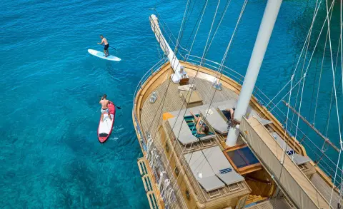 Libra luxury yacht deck above turquoise sea with aerial view, sun loungers and rigging