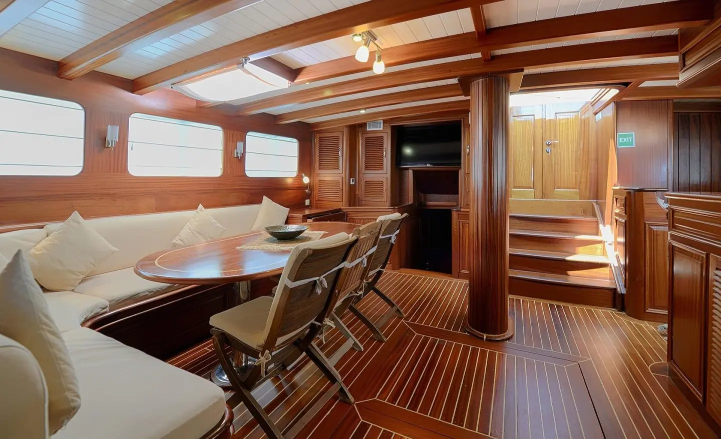 Zephyria II yacht interior with teak deck, seating area, and warm lighting at dusk