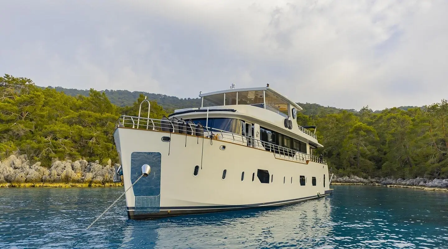 Yacht Simay M anchored in calm blue water with multiple decks and white hull