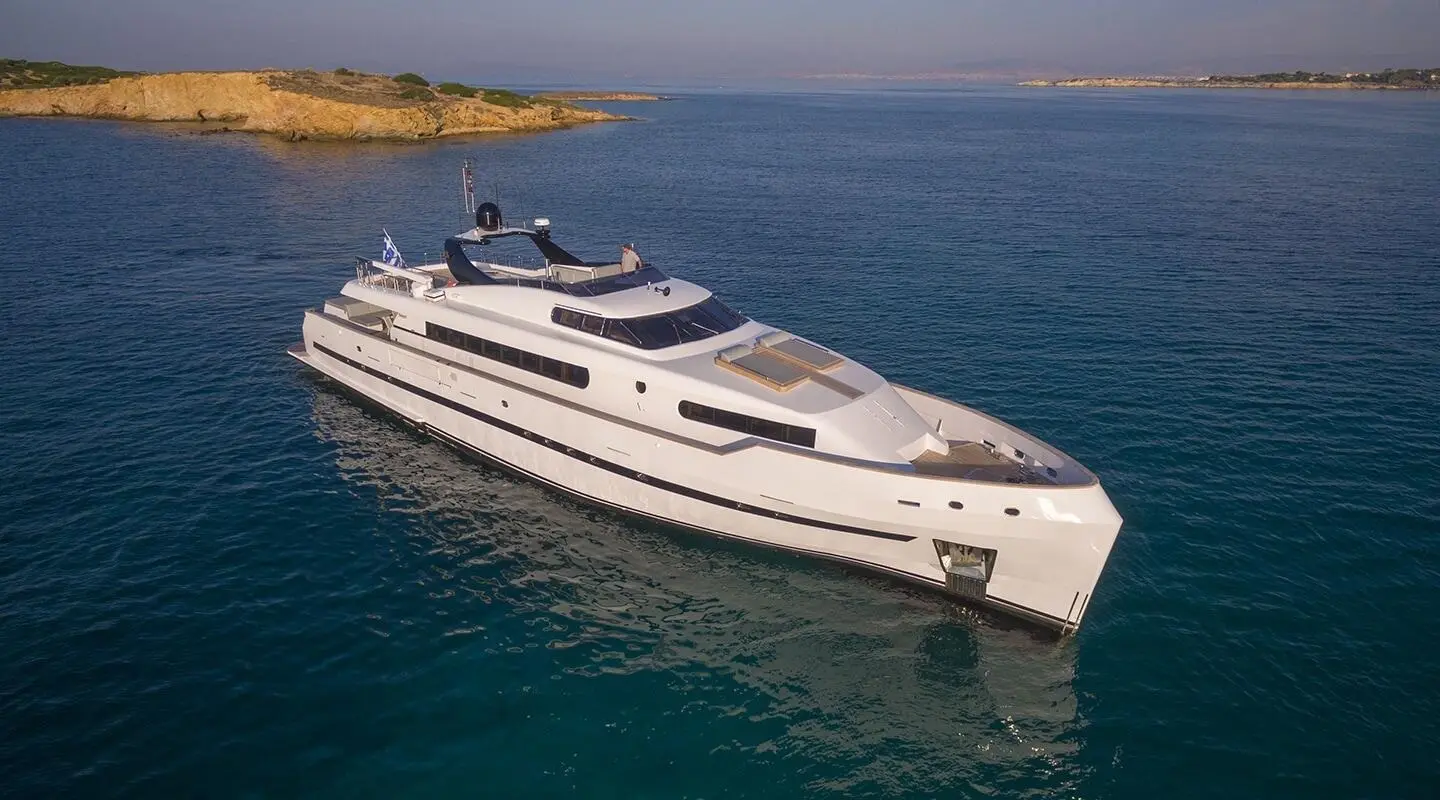 Yacht Project Steel anchored in calm blue water near coastline, white vessel