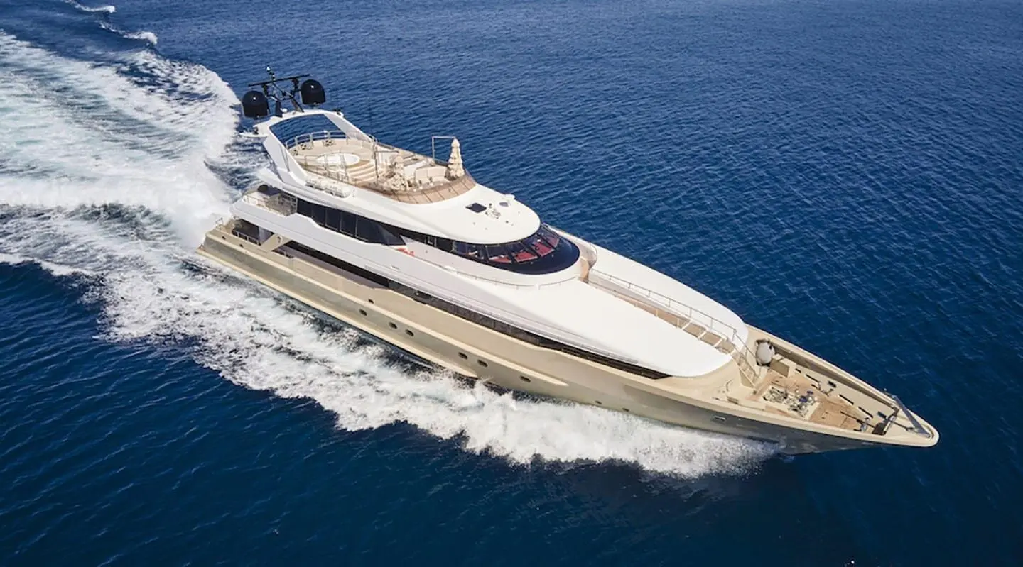 A sleek motor yacht named Daloli glides through blue sea waters