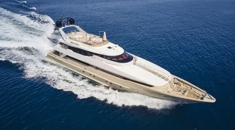 A sleek motor yacht named Daloli glides through blue sea waters