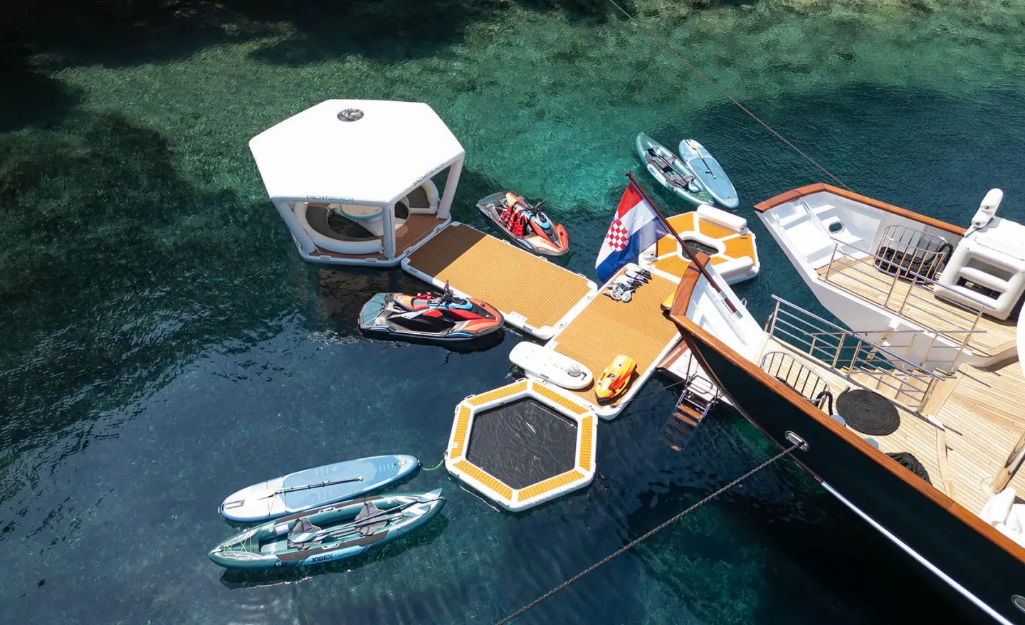Maia luxury yacht deck scene with stairs, lifebuoys, and small boats