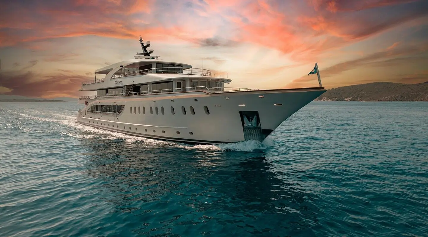 Sunlit luxury Riva yacht anchored on calm teal sea at sunset