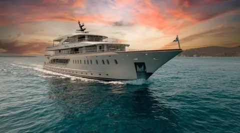 Sunlit luxury Riva yacht anchored on calm teal sea at sunset