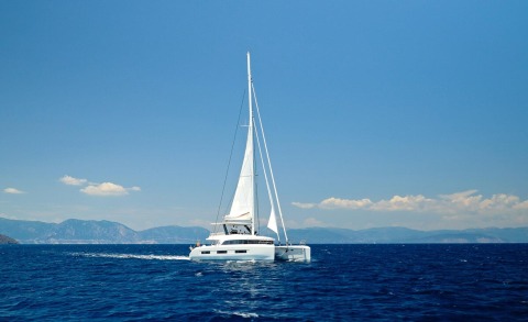Daiquiri sailing yacht on blue sea under clear sky, white hull and tall mast