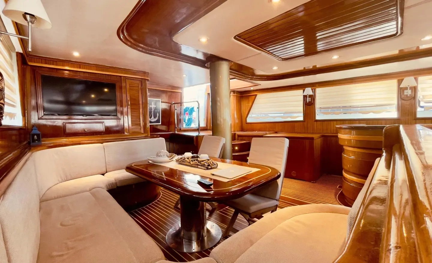 Interior of gulet Diva Deniz saloon with wooden table and beige seating