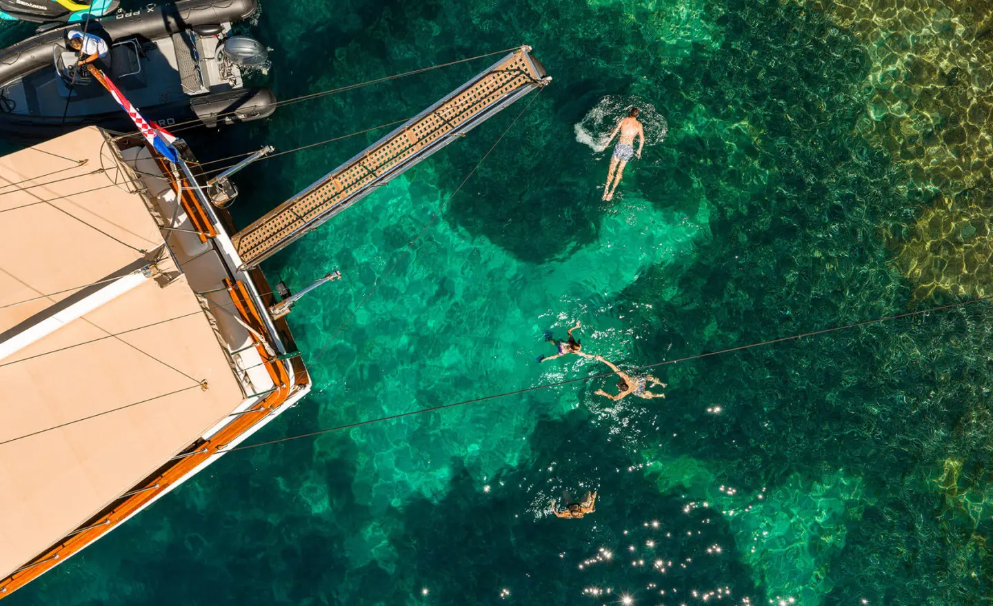 Eleganza yacht anchored in turquoise sea at sunset, view from above