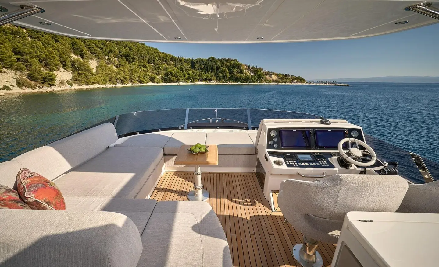 Sunset view from the Hideaway yacht cockpit with white seating and wooden deck
