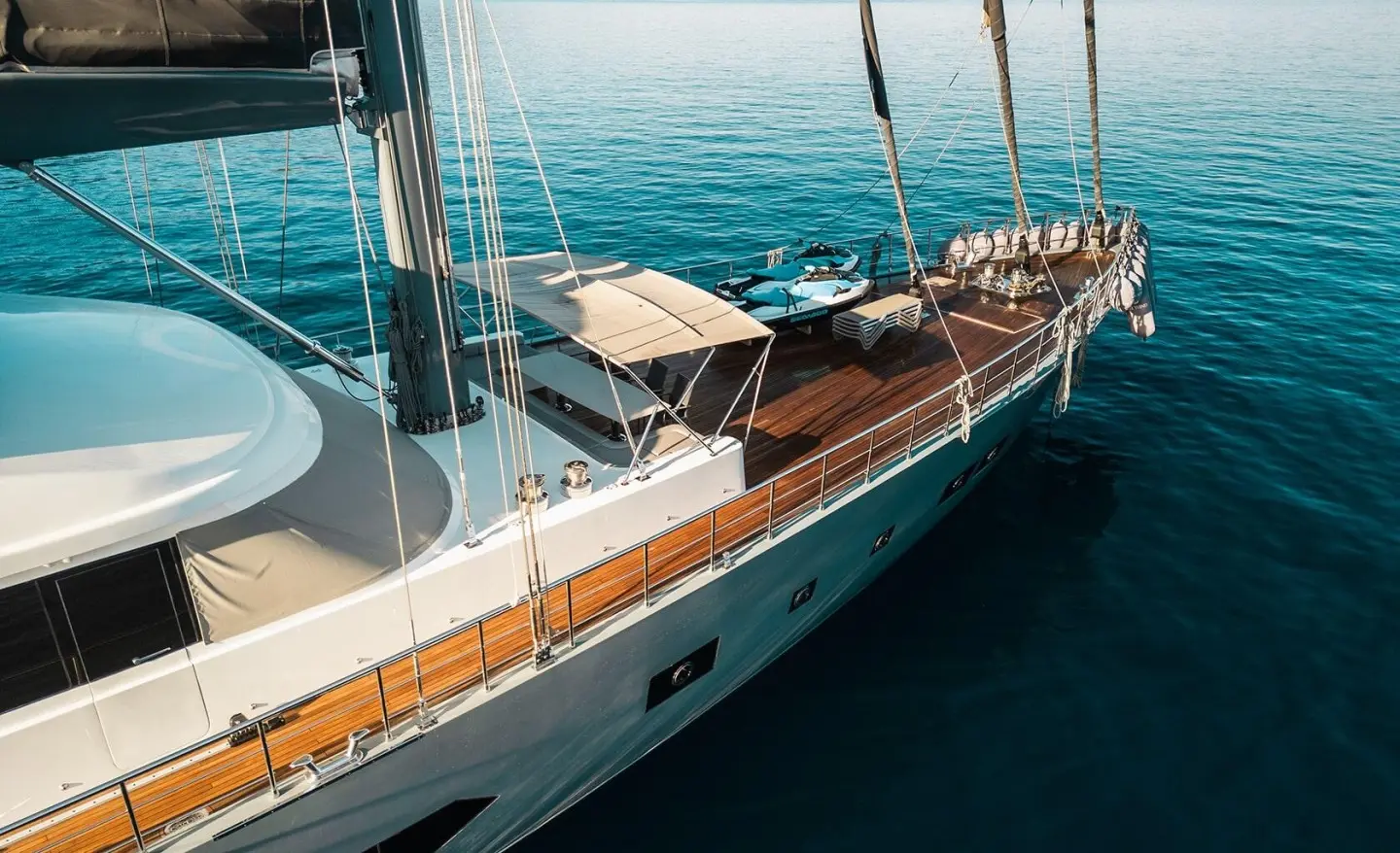North Wind yacht deck with polished wood, railing, and sun loungers at sea