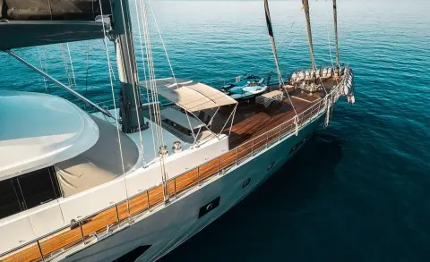 North Wind yacht deck with polished wood, railing, and sun loungers at sea