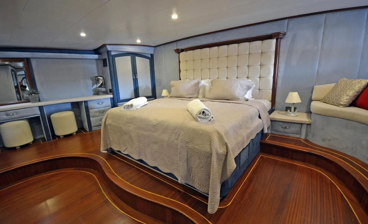 Yacht Bella Mare interior: luxurious bed, padded headboard, warm lighting