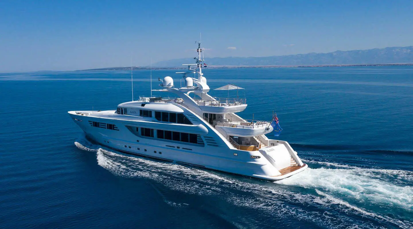 Yacht Alalya cruising on calm blue sea with clear sky and radar mast