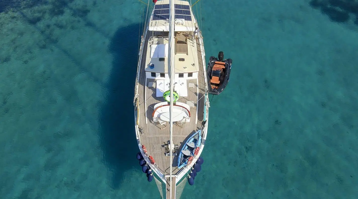 Top-down view of a white luxury yacht anchored in turquoise water, Gazella