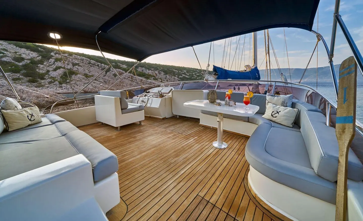 Lotus yacht deck seating on a wooden deck at sunset with harbor and boats