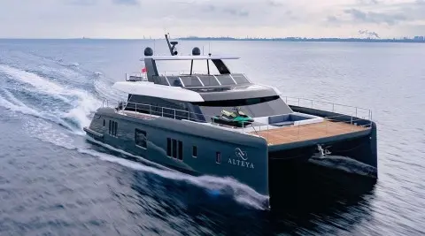 Alteya luxury motor yacht cruising, sleek dark hull, open aft deck and sun loungers