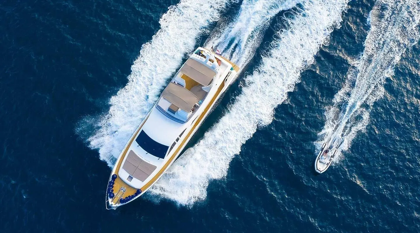 Aerial view of Quo Vadis I yacht cruising with a smaller motor boat nearby