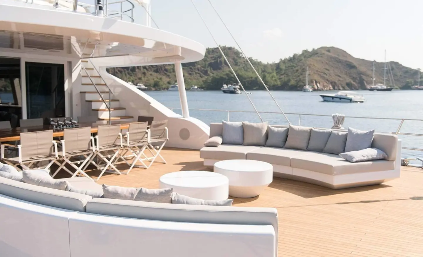 All About U 2 yacht deck with white lounge seating and seating area by the water