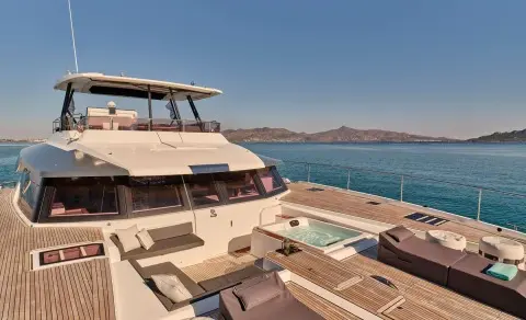 Bow deck of Christal Mio yacht with sun loungers and blue sea