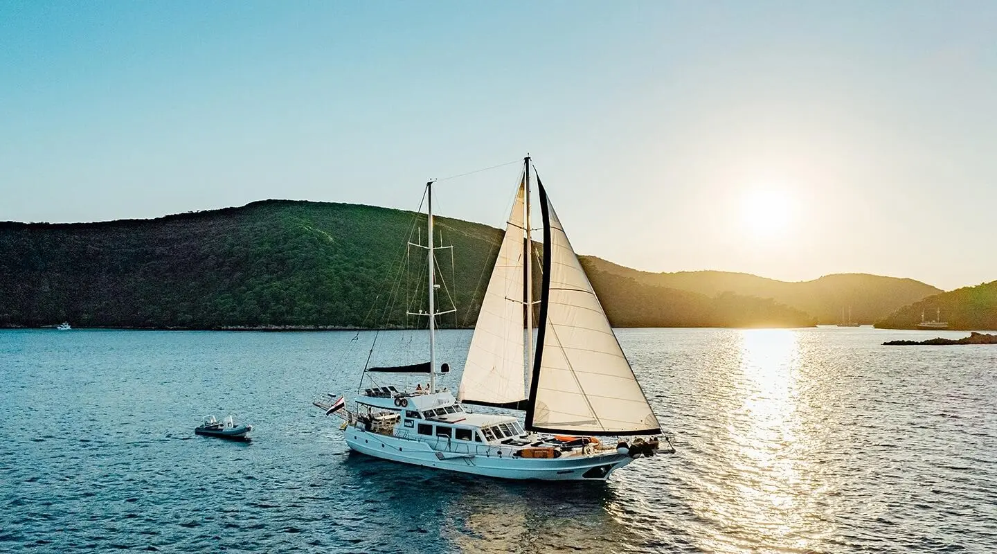 Maske yacht with a large sailing catamaran in sunset on the water