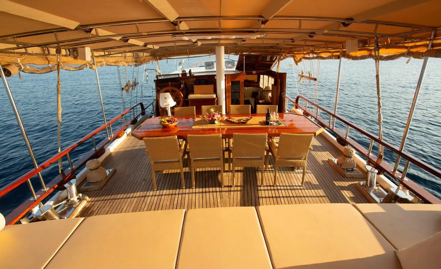 Malena yacht with sunlit deck and seating area at sunset on calm turquoise sea