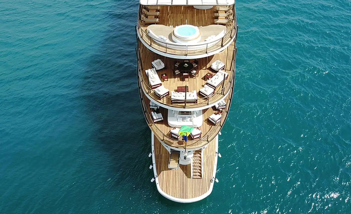 Top-down view of Chakra luxury yacht anchored in clear blue water, sunlit deck
