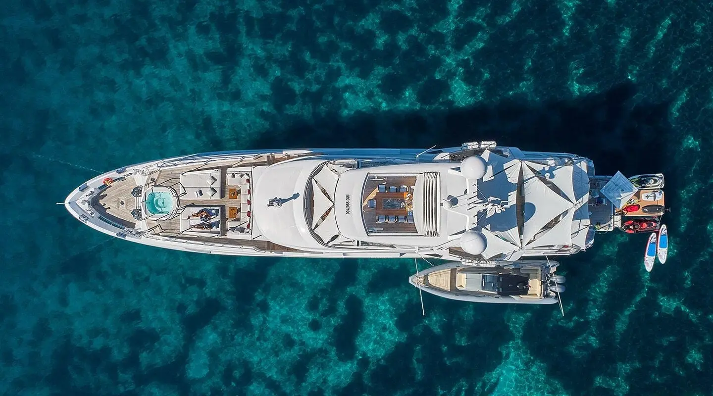 Top-down view of a white luxury yacht named Happy Me in clear blue water