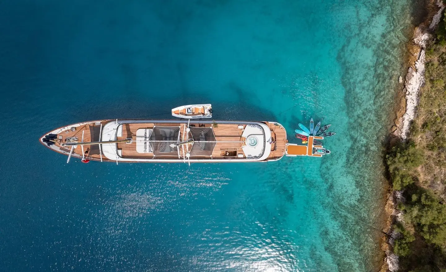 Aerial view of Anima Maris motor yacht anchored in turquoise sea, wooden deck