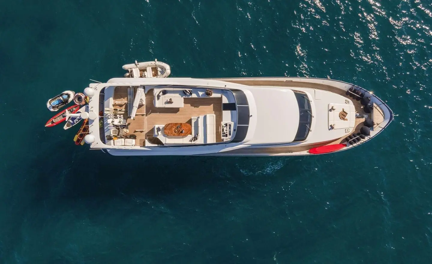 Aerial view of the motor yacht Zoi cruising blue-green sea, teak deck visible
