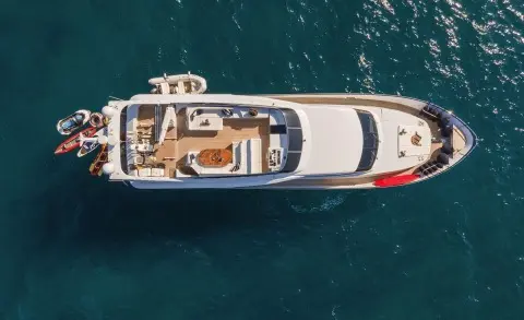 Aerial view of the motor yacht Zoi cruising blue-green sea, teak deck visible