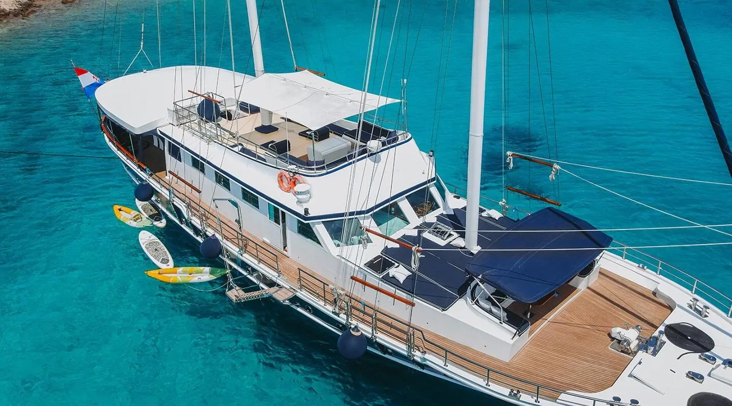 Aurum gulet anchored in turquoise sea, two-deck yacht with white hulls