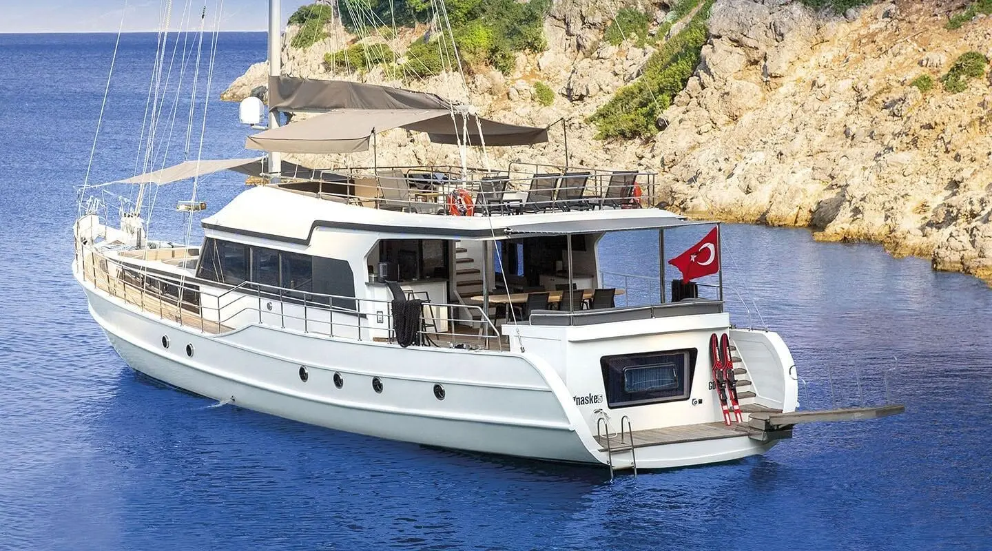 Maske 5 luxury gulet yacht anchored near rocky coastline at sunset