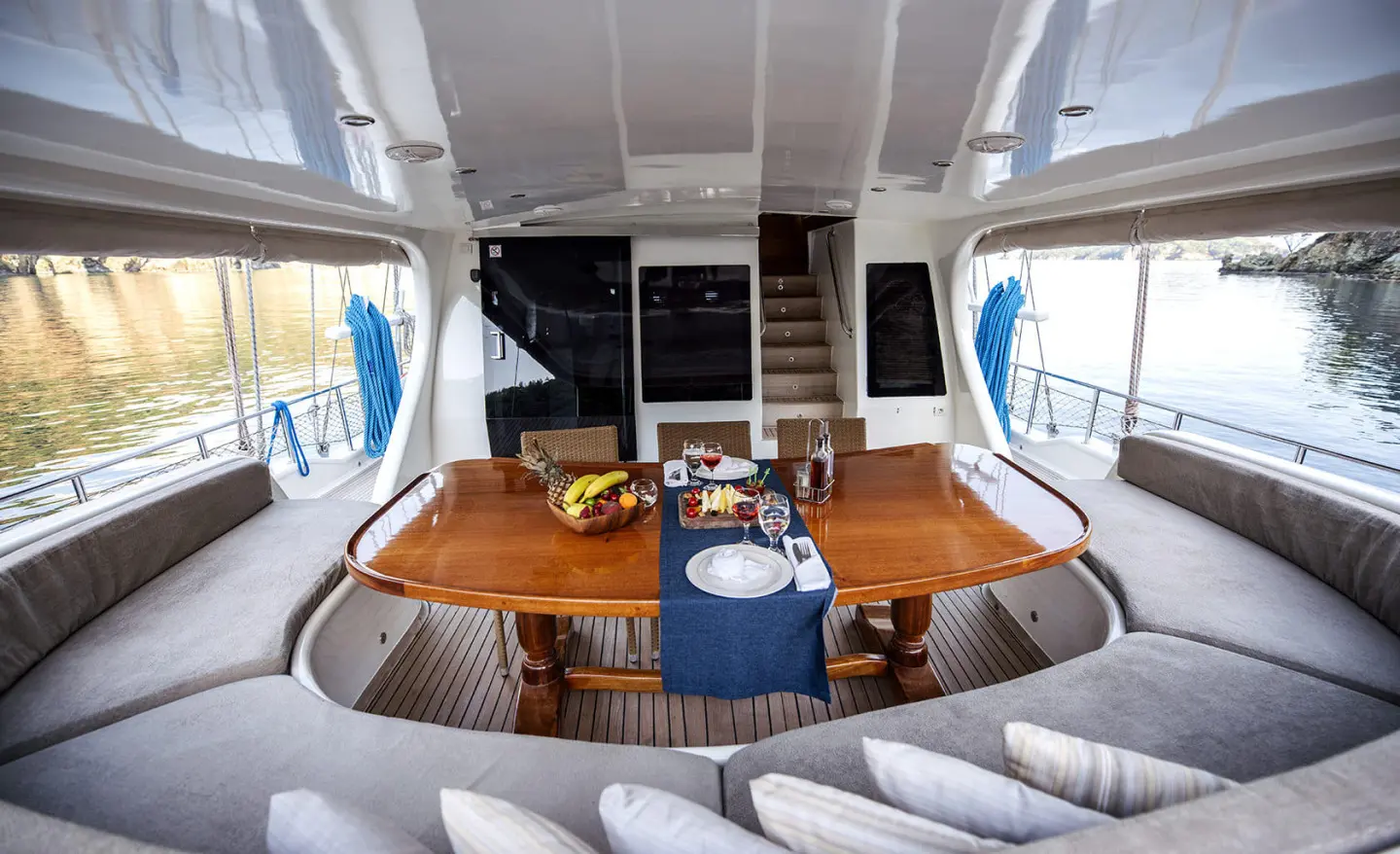 Kayhan 4 yacht interior dining area with round table and seating under shaded deck