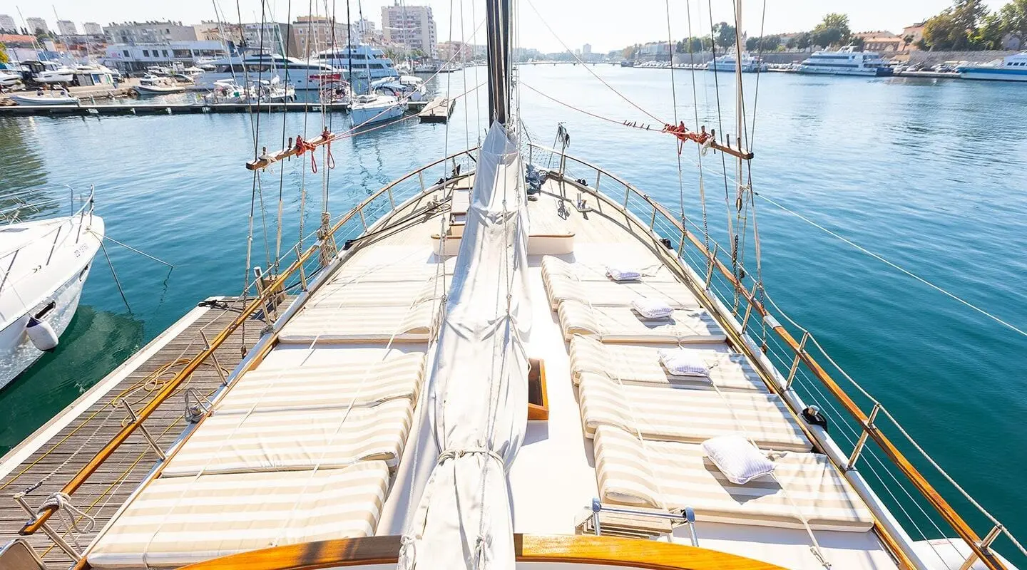 Gardelin yacht deck view at sunset, masts, railing, calm harbor water