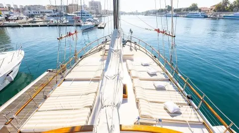 Gardelin yacht deck view at sunset, masts, railing, calm harbor water