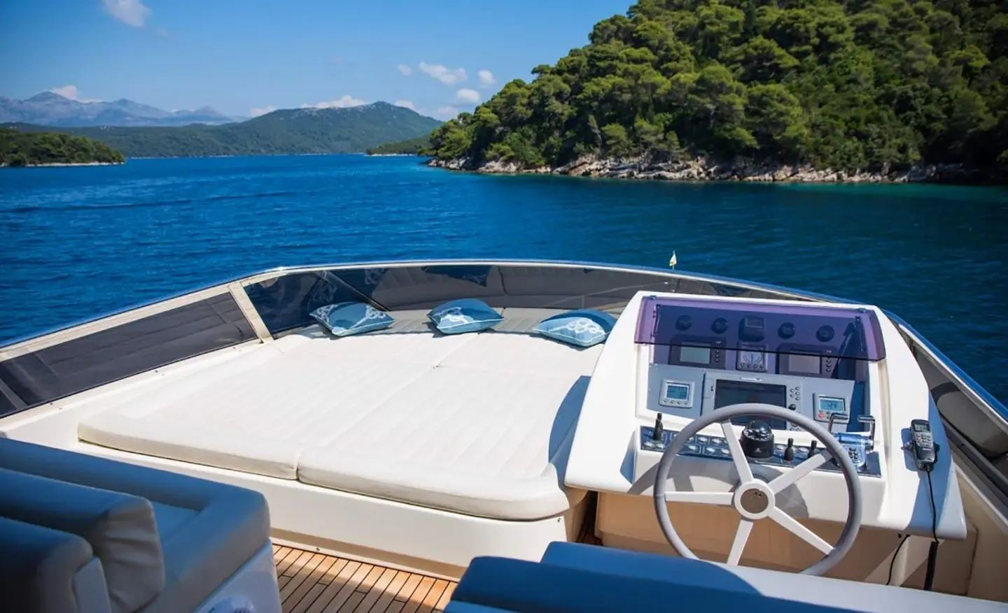Sunset view from the Salt yacht deck with blue seats and seaside cliffs
