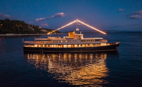 Seagull II luxury yacht at night, illuminated deck and string lights over calm sea