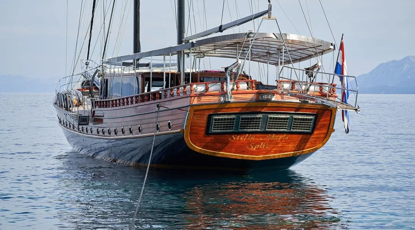 Wooden luxury yacht Stella Maris on calm water with a deck and stern details