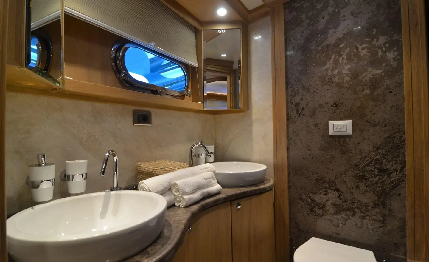 Bathroom on Blue Heaven gulet with wooden vanity, sink, mirror, and towel