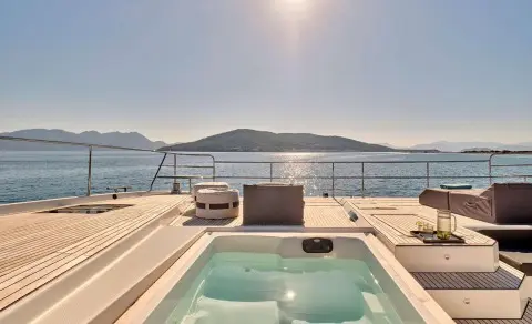 Christal Mio luxury yacht deck with hot tub overlook calm sea and distant hills