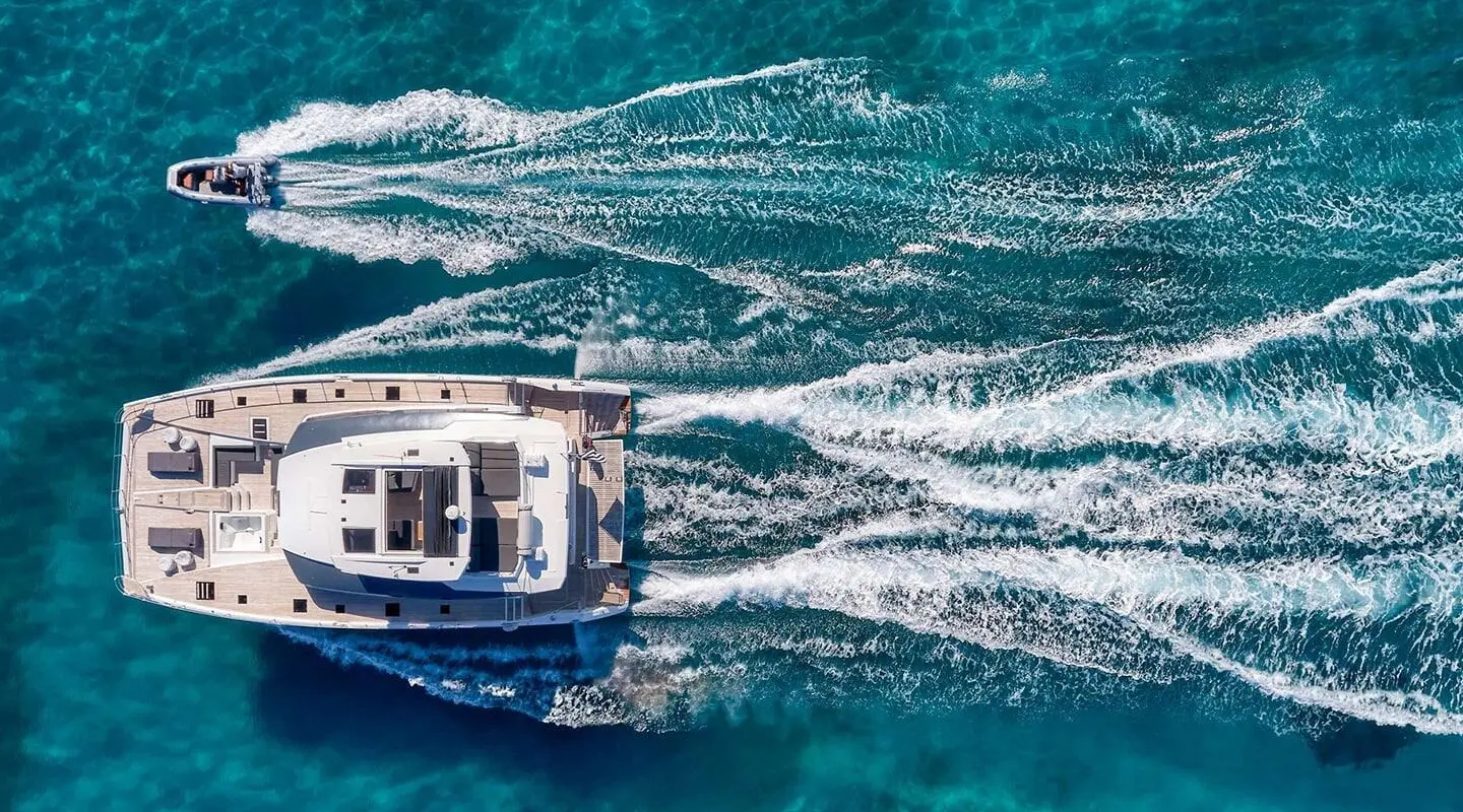 Christal Mio yacht cruising at sunset with wake patterns in turquoise sea