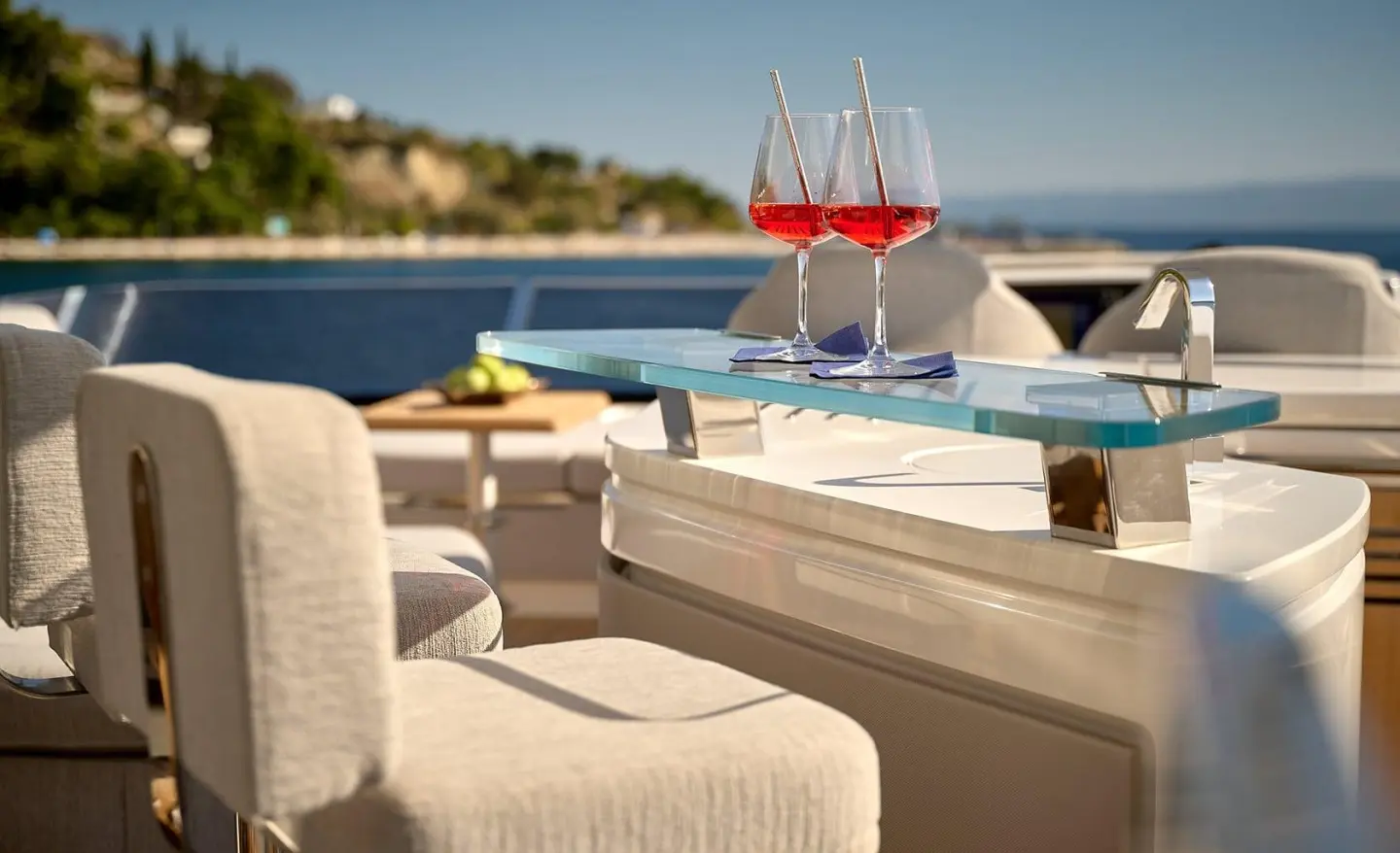 Yacht Hideaway deck with lounge chairs, glasses, and sea view