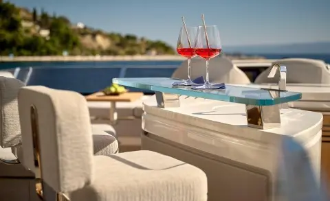 Yacht Hideaway deck with lounge chairs, glasses, and sea view