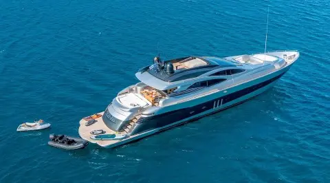 Luxurious motor yacht with open aft deck anchored in blue sea
