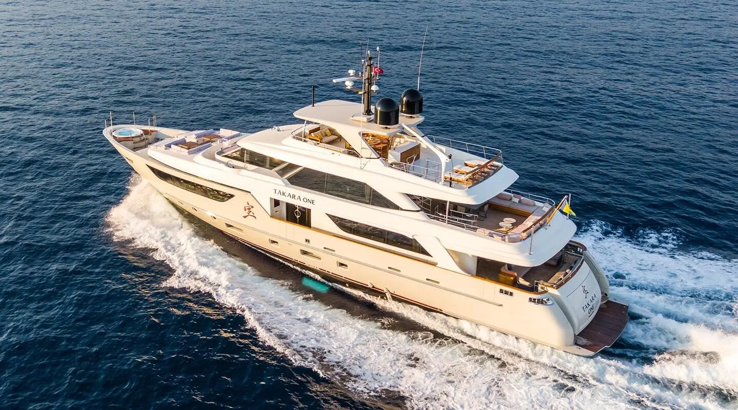 Takara One yacht cruising on blue sea, white hull, windows, deck seating
