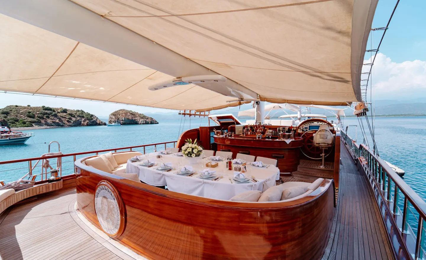 Lycian Queen yacht deck with polished wood, seating, and a red lifebuoy under sunshade