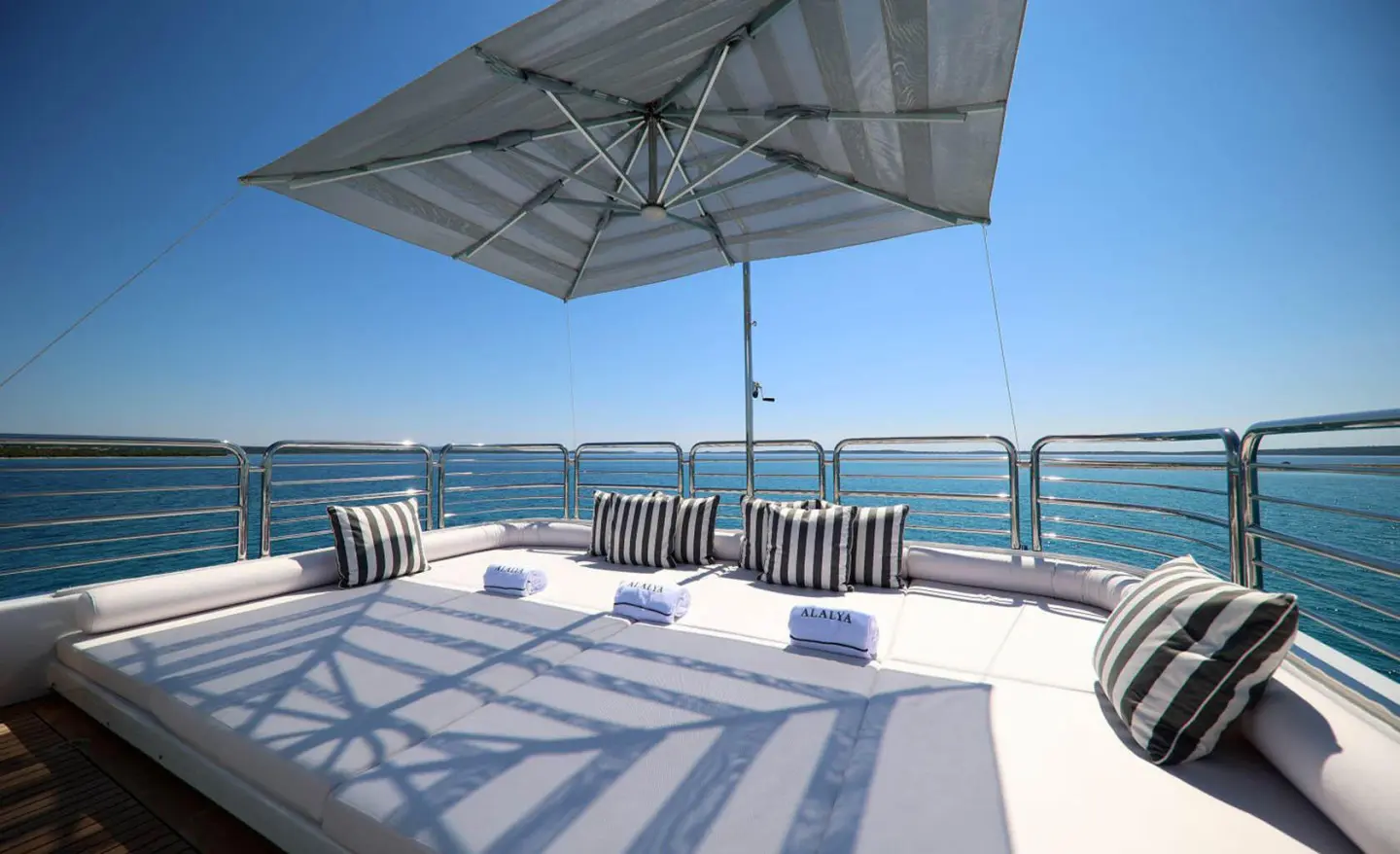Deck seating area on Alalya yacht with umbrella and ocean view