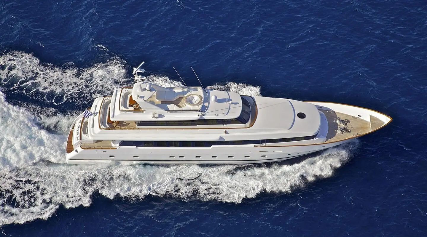 White luxury motor yacht cruising on blue sea, aerial view