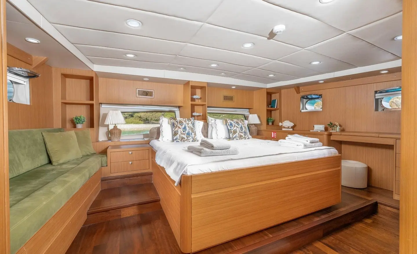 Artemis luxury yacht interior with wooden floors, beds, and warm lighting